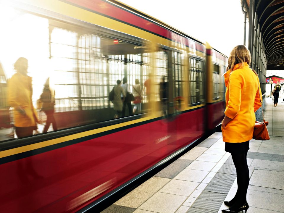 Picture of a person on a train station platform, a train in the background