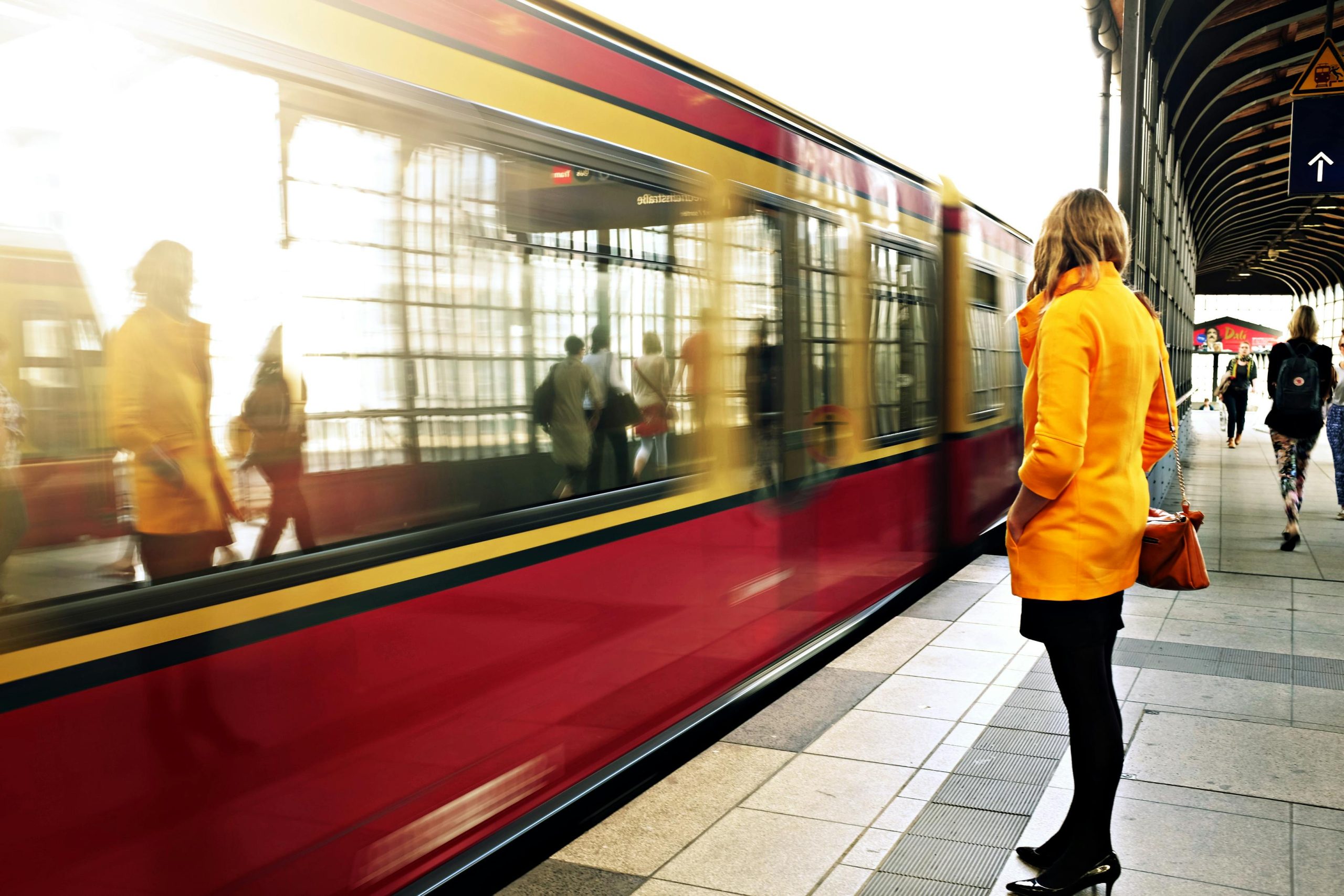 Picture of a person on a train station platform, a train in the background